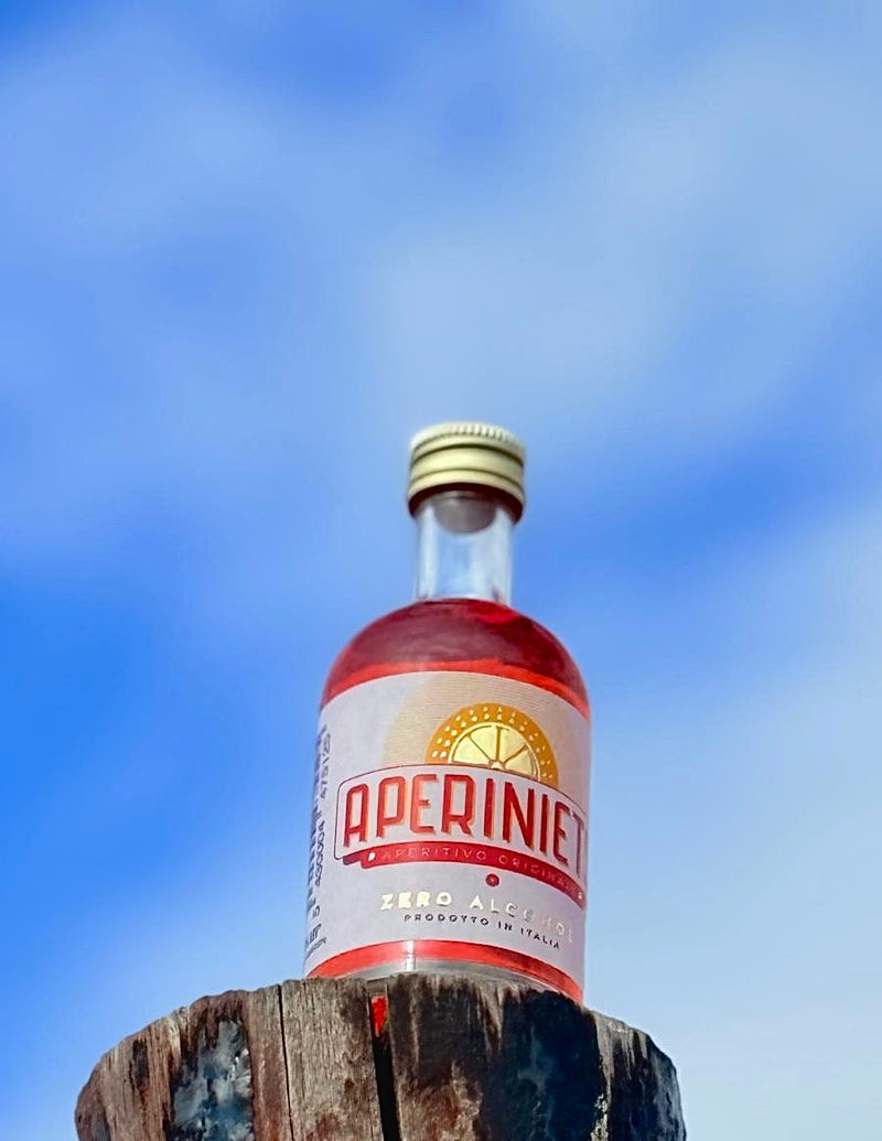 Aperiniets bottle against blue sky, highlighting Aperiniets Brussels Airlines partnership.