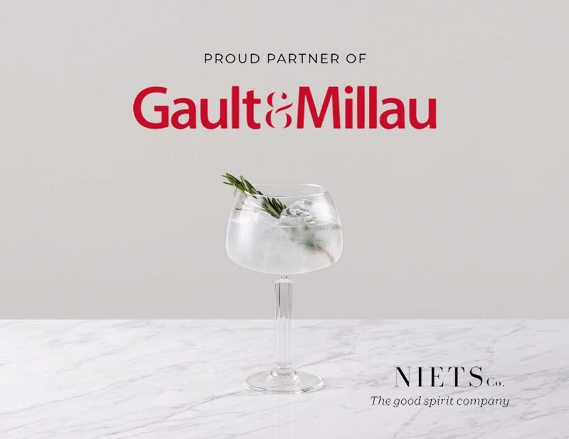 Niets official partner of Gault&Millau with a stylish cocktail on marble table.