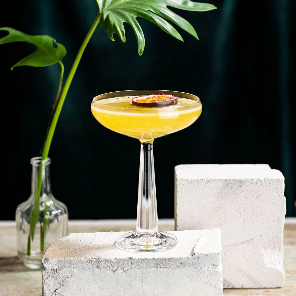 Delicious Pornstar Martini served in a sleek glass with a passion fruit garnish, surrounded by minimalistic decor.