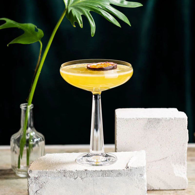 Delicious Pornstar Martini served in a sleek glass with a passion fruit garnish, surrounded by minimalistic decor.