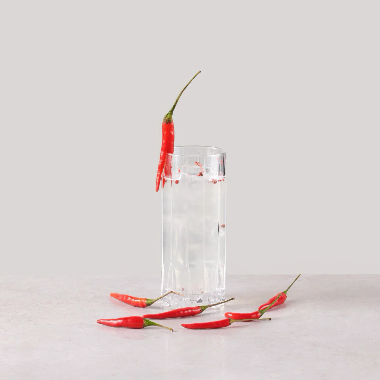 Niets Fix cocktail with ginger beer and red peppers in a highball glass, showcasing freshness and flavor.