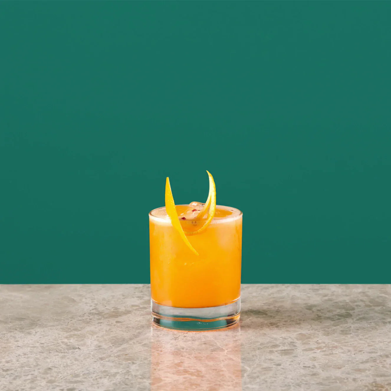 Sling cocktail served in a whisky glass, featuring orange juice and Angostura Bitter, garnished with orange peel.
