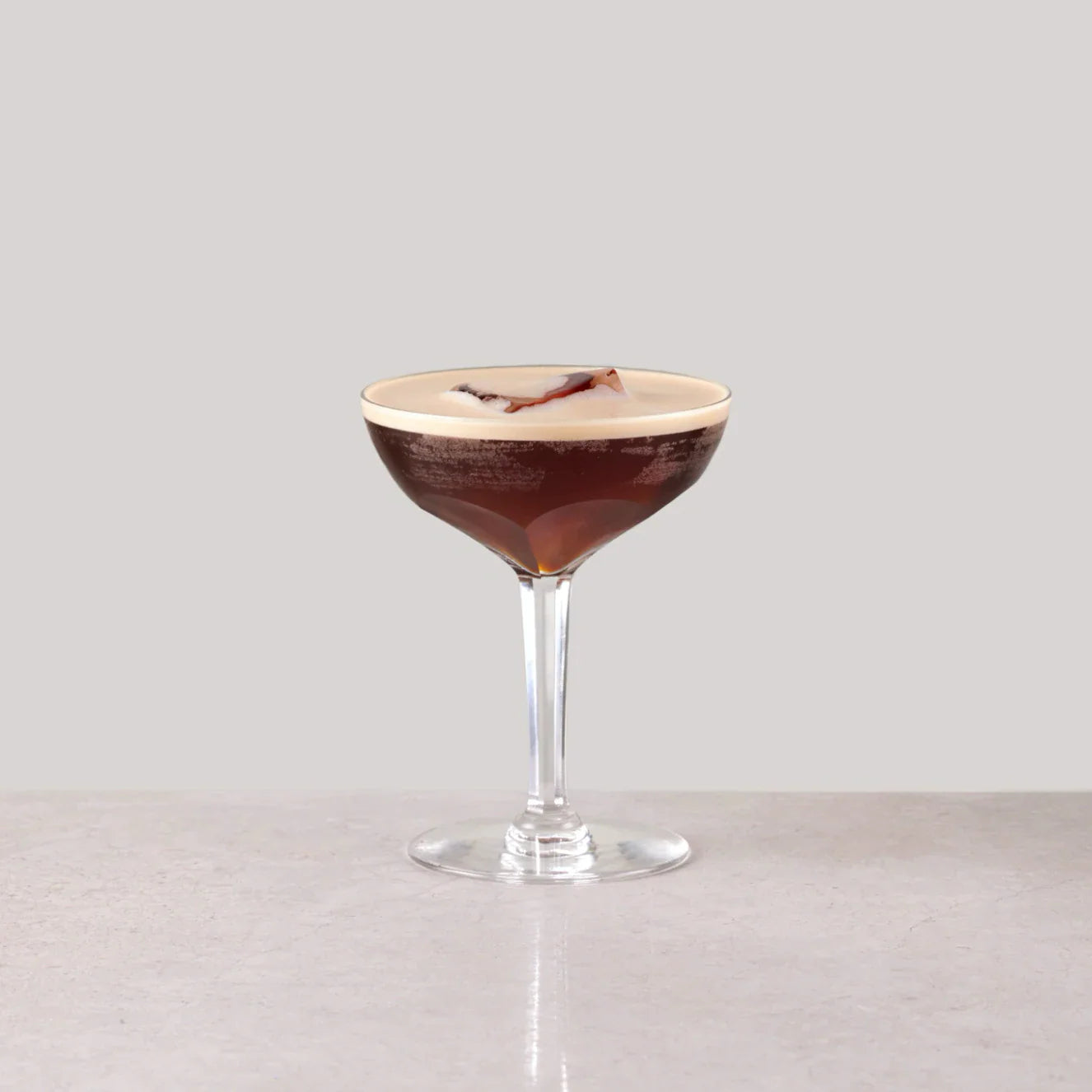 Niets Frappé cocktail in a glass, topped with cream and garnished, showcasing its rich espresso color.