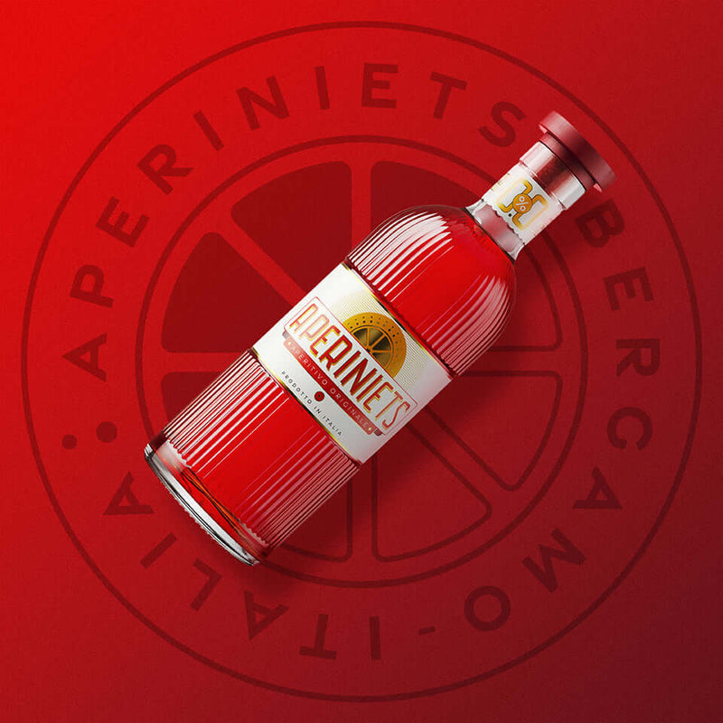 APERINIETS Non alcoholic Italian Aperitif bottle against a vibrant red background.